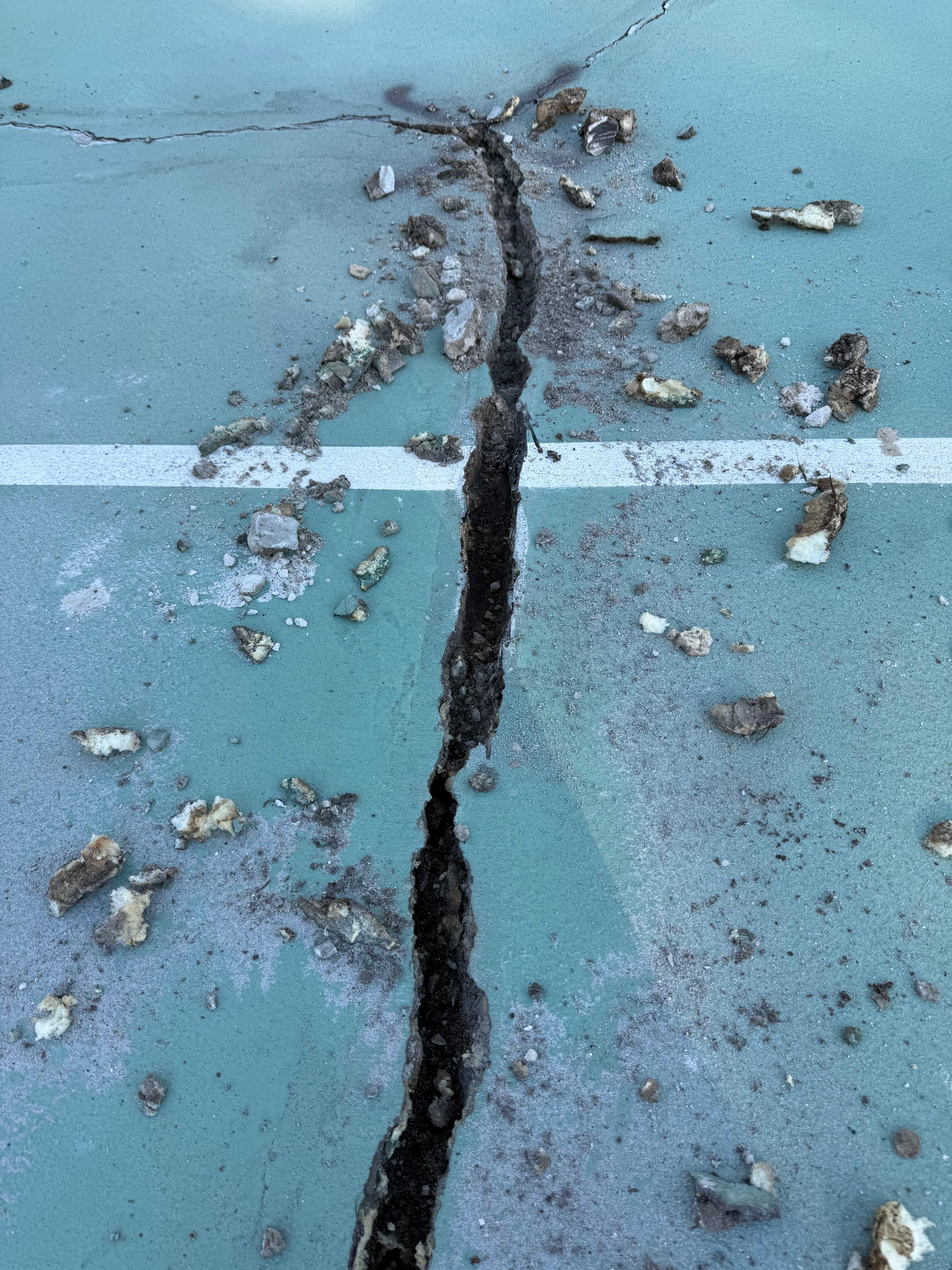 Hairline cracks across a tennis court surface in Concord, NC